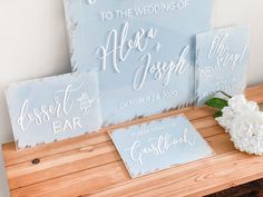 wedding signs and flowers sitting on a wooden bench