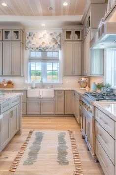 a kitchen with beige cabinets and white counter tops, an area rug on the floor