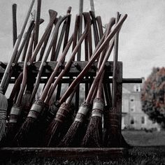 a pile of brooms sitting on top of a wooden crate