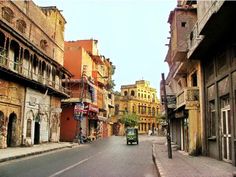 an old city street with cars parked on both sides