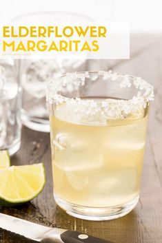 a close up of a drink on a table with limes and a knife next to it