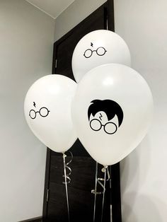 three white balloons with harry potter faces on them