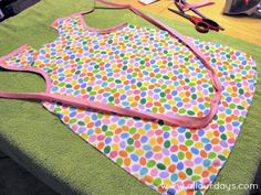 a pair of scissors sitting on top of a table next to an apron and bib