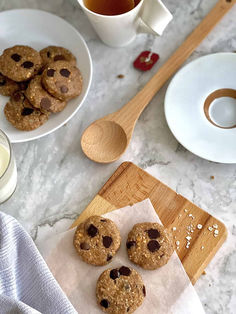 chocolate chip cookies on a cutting board next to a cup of tea