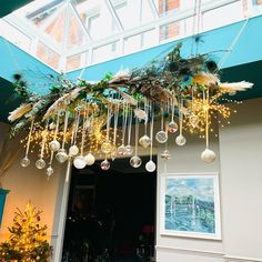 an entrance decorated with christmas decorations and ornaments hanging from it's ceiling above the door