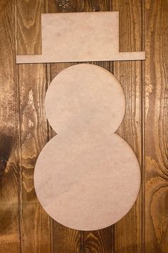 an unfinished piece of wood with the shape of a snowman cut out on it