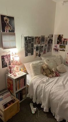 there is a teddy bear on the bed in this room with many pictures all over it