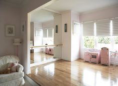 a living room with hardwood floors and pink furniture