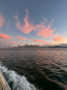 the sun is setting over the city as seen from a boat