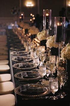 a long table is set up with silverware and candles for an elegant dinner party