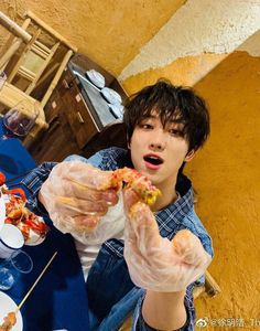 a young man sitting at a table eating food