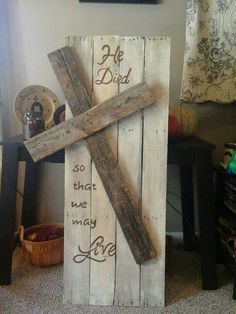 a cross made out of wood with words written on it and a basket next to it