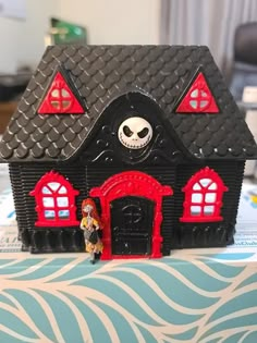 a toy house with a skeleton on the roof