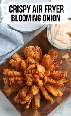 crispy air fryer blooming onion on a cutting board with dip in the background