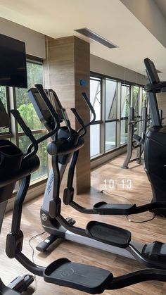 there are many treadmills in the gym with glass doors on each side and windows to the outside