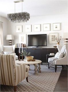 a living room filled with furniture and a flat screen tv on top of a wall