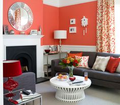 a living room filled with furniture and a fire place in front of a mirror on the wall