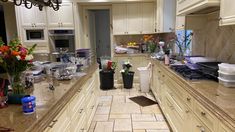 a kitchen filled with lots of counter top space and flowers in vases on the counters