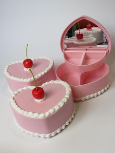 two heart shaped cakes with cherries on top and a mirror in the back ground