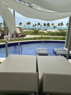 two lounge chairs sitting next to a swimming pool