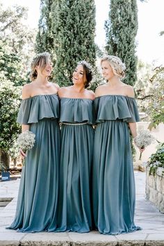 three bridesmaids posing for the camera in their dresses