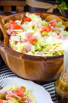 a salad in a wooden bowl on top of a table