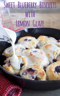 blueberry biscuits with lemon glaze in a skillet being drizzled