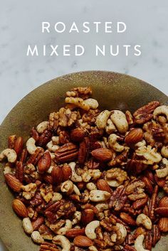 roasted mixed nuts in a bowl on a marble counter top with the words roasted mixed nuts above it