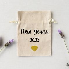 a new year's bag next to some lavenders on a white surface with the words 2012 printed on it