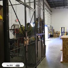 the inside of an industrial warehouse with lots of wire mesh doors and tools in it