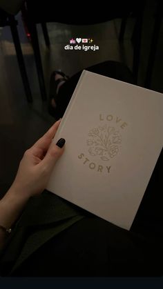 a person holding a book in their hand with the words love story written on it