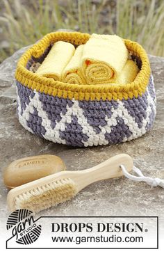 a crocheted basket with two towels and a brush