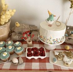 a table topped with cakes and cupcakes on top of a checkered table cloth