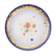 a blue and gold plate with small pieces of food in it on a white surface