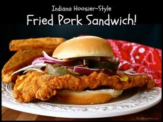 fried pork sandwich on a plate with fries