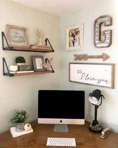 a desk with a computer and some pictures on the wall