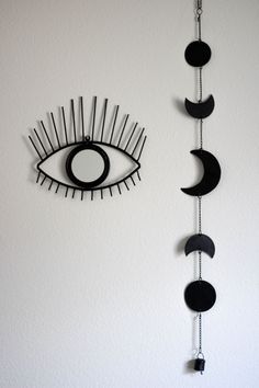 a clock with spikes on it and an evil eye hanging from the wall behind it