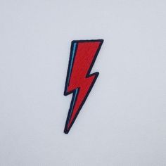 a red and blue lightning bolt embroidered on a white shirt