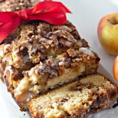 a loaf of cinnamon apple bread on a white plate with two apples in the background