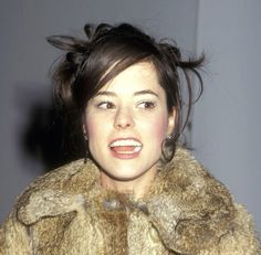 a woman wearing a fur coat and looking at the camera with an angry look on her face