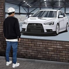 a man standing next to a white car on a brick wall in front of a building