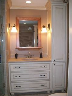 a bathroom with white cabinets and a large mirror