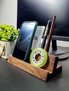 a cell phone and pen holder on a desk