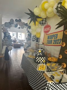 a table topped with lots of food and balloons