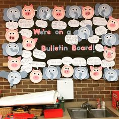 a bulletin board with pigs and piggies on it in front of a brick wall