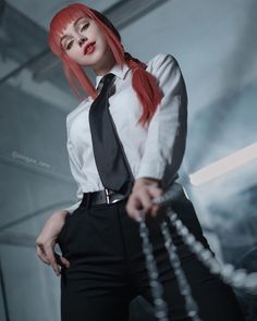 a woman with red hair wearing a black tie and white shirt is posing for the camera