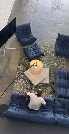 a man sitting on top of a blue couch