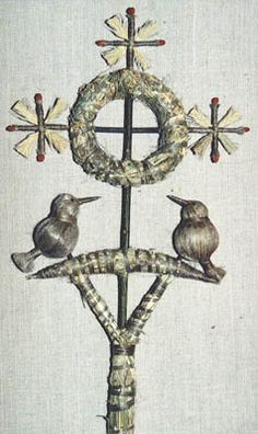 three birds sitting on top of a cross with two crosses in the middle and one bird perched on it's back