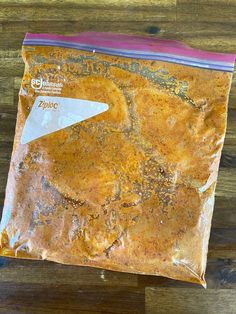 a close up of a bag of food on a wooden table with a knife in it