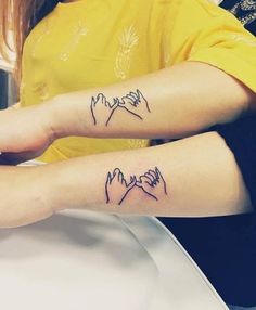 two people with matching tattoos on their arms